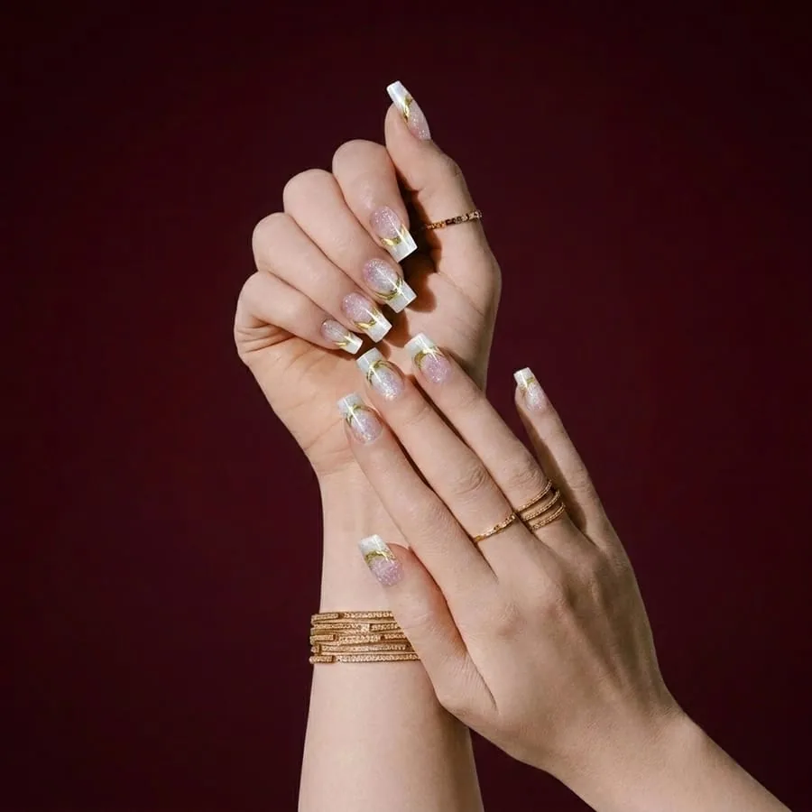 Nail art personalizada com traços dourados